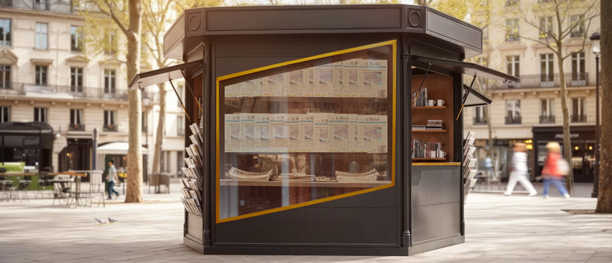 Street view of a traditional Parisian newspaper kiosk with yellow-framed windows displaying publications, where the window frame forms SynaPay's parallelogram logo.